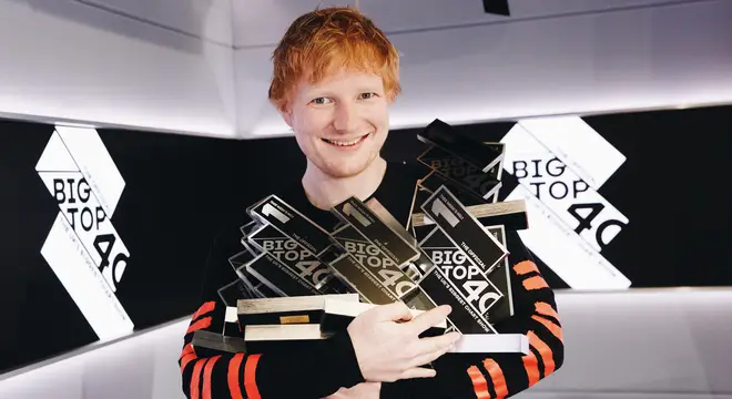Ed Sheeran poses with his 14 Official Big Top 40 from Global Number 1 trophies