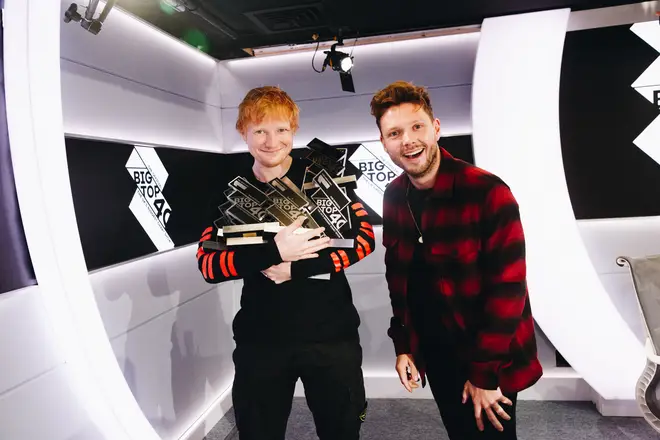 Ed Sheeran holding his Number 1 trophies alongside Will Manning