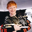 Ed Sheeran pictured with his Number 1 trophies